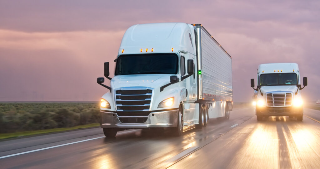 Deux camions blancs vus de face sur l’autoroute