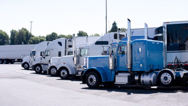 Truck stop with row of big rigs semi trucks alternate text for this image