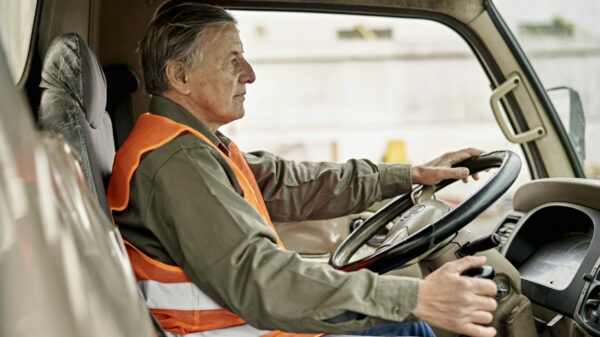 Portrait of Early 60s Trucker Sitting in Driver’s Seat alternate text for this image