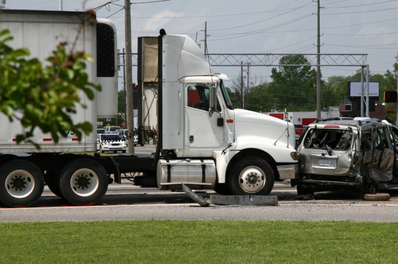 Camion blanc qui a embouti une voiture à une intersection.