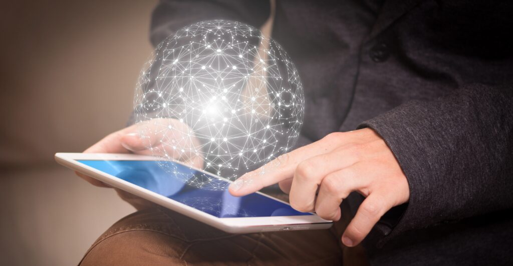 Mains qui tiennent une tablette avec une image de la planète Internet au-dessus.