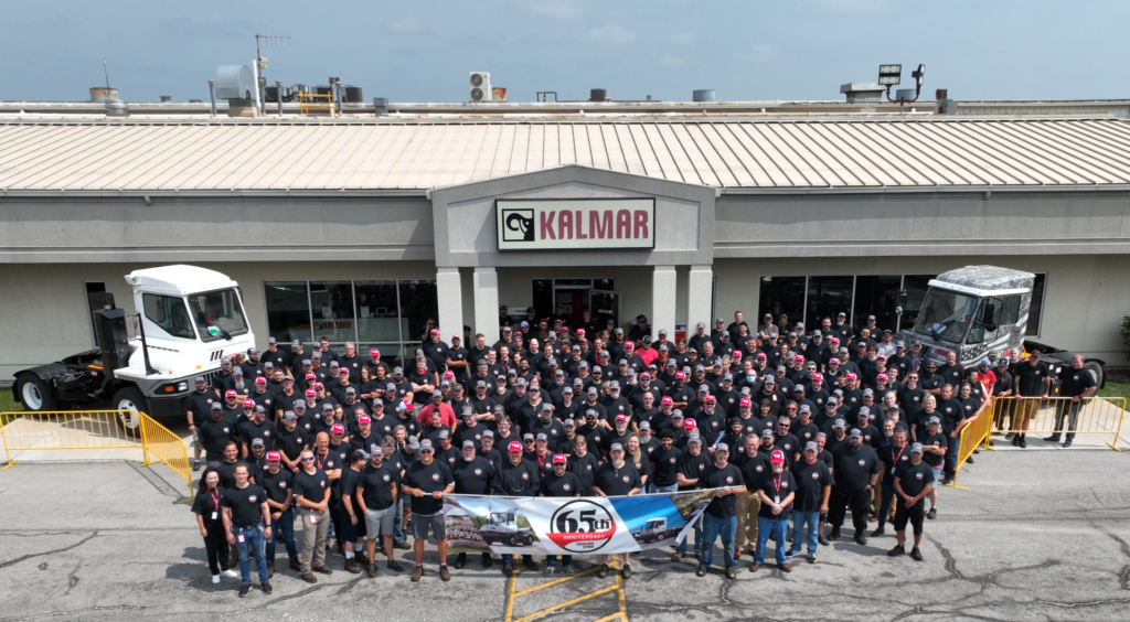 Groupe avec bannière 65 ans devant édifice Kalmar Ottawa.