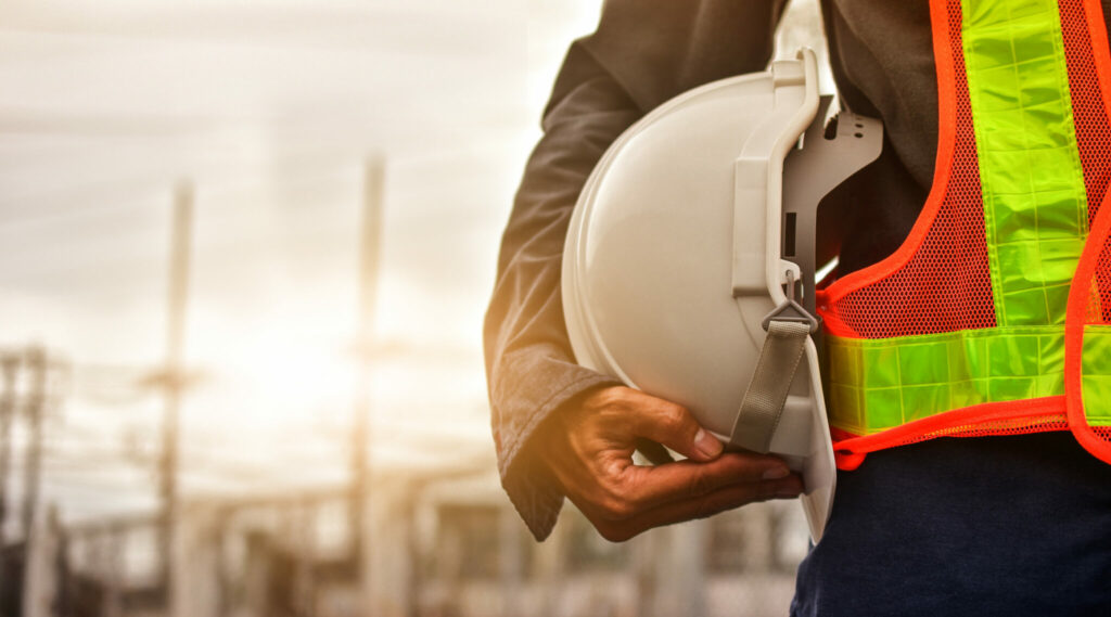 Technician holding white hat safety hard hat sunlight background alternate text for this image