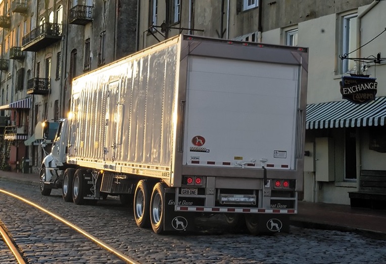 Camion et remorque vus de l’arrière sur une artère commerciale