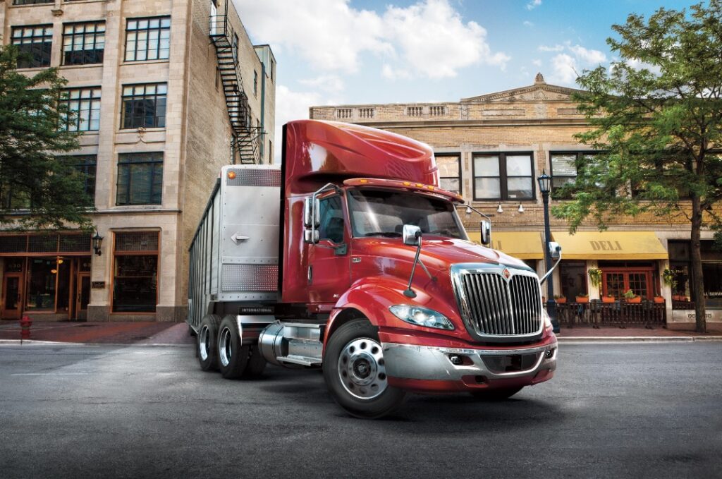 Camion Navistar RH recule sa remorque vers quai en milieu urbain
