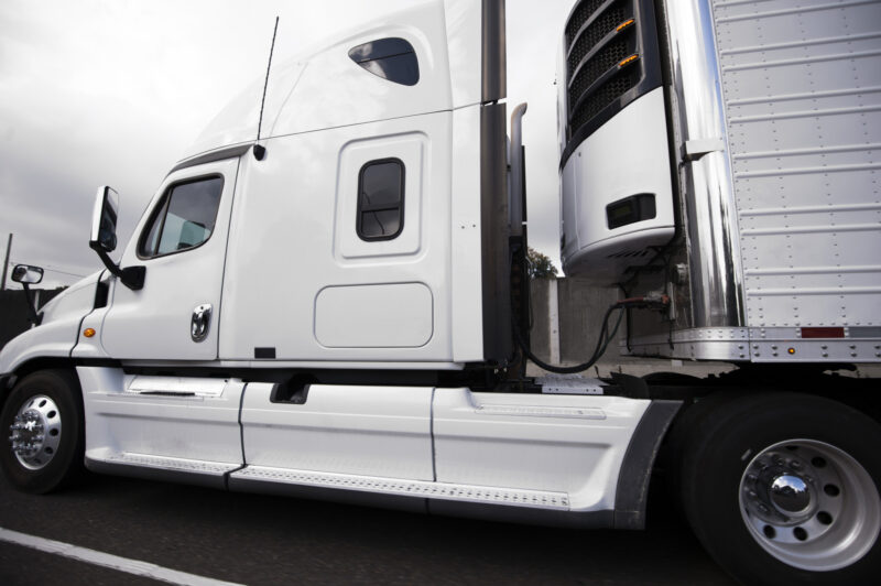 Camion blanc sur autoroute vu de côté