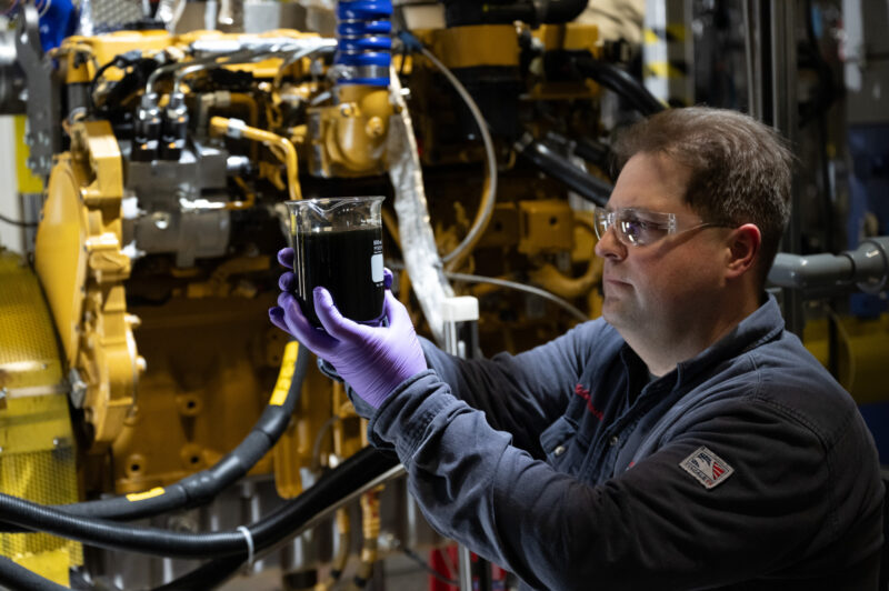 Technicien analyse de l’huile moteur, gros moteur diesel en arrière-plan