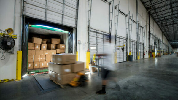 Worker Unloading Truck at Warehouse Loading Dock alternate text for this image