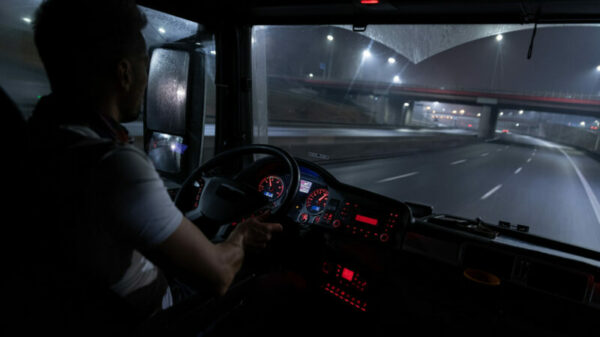 Handsome driver at the wheel of a truck at night. alternate text for this image