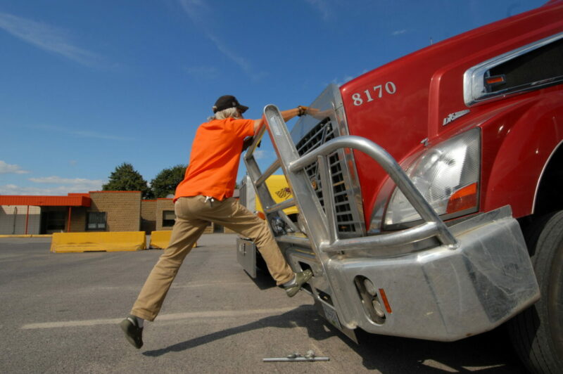 Chauffeur tire le capot d’un camion pour l’ouvrir