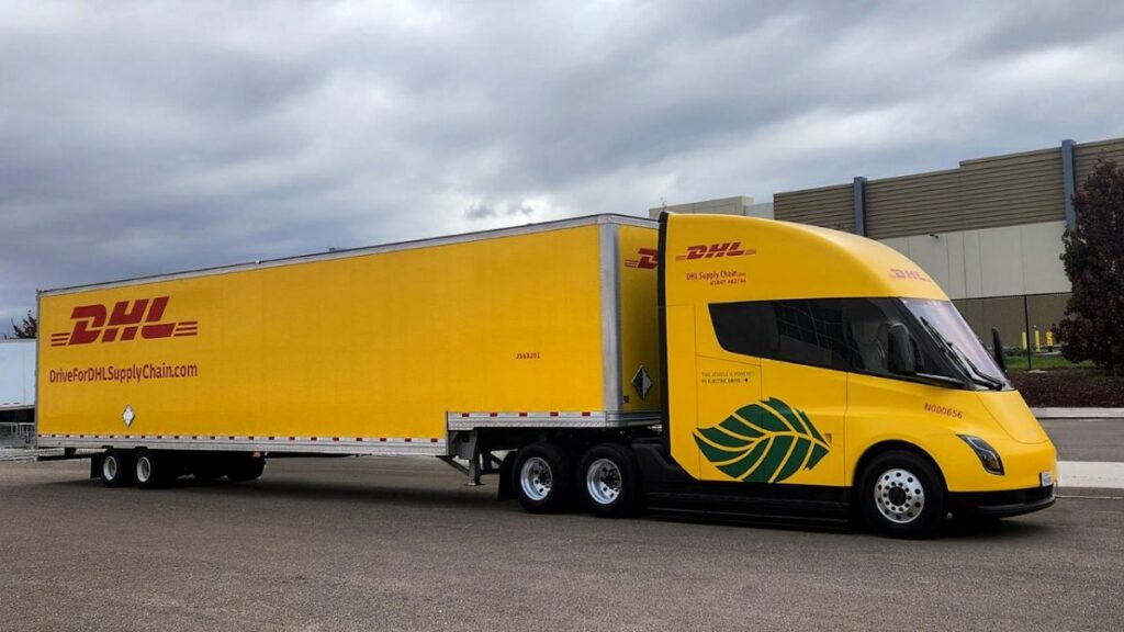 Vue de côté d’un Semi de Tesla attelé à une remorque DHL