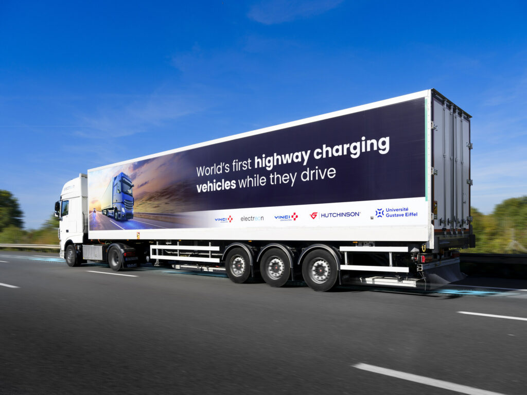 Camion électrique en recharge en mouvement, vu de ¾ arrière