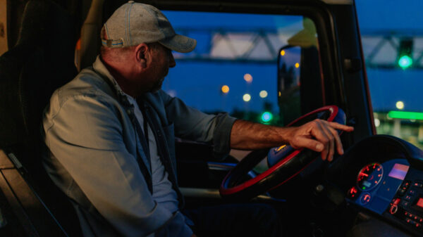 Adult man turning the wheel of a truck into the right alternate text for this image