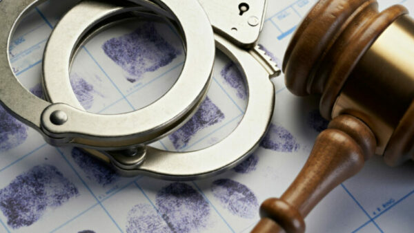 Gavel and handcuffs on fingerprints: Arrest crime concept alternate text for this image