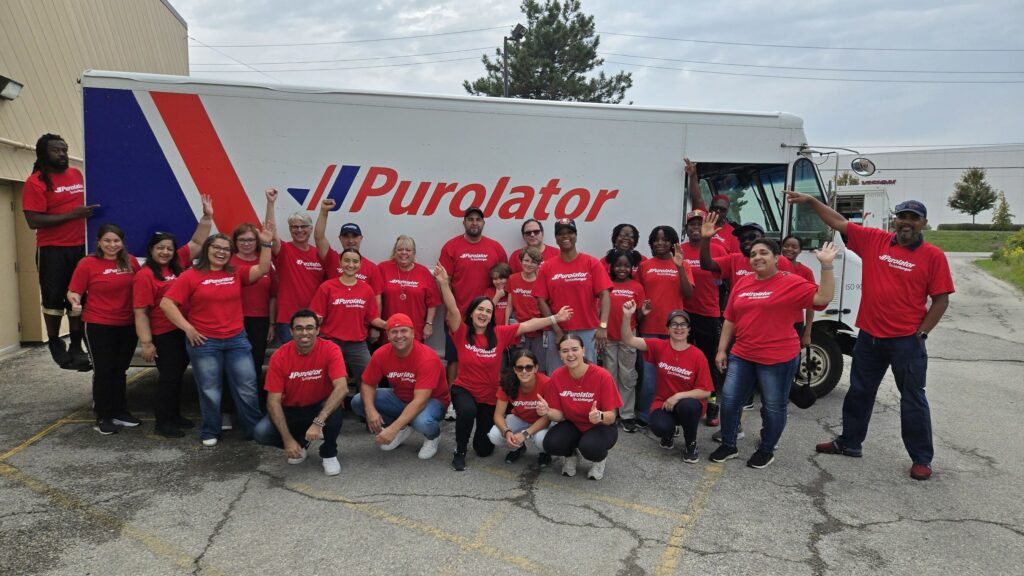 Groupe de bénévoles pour les banques alimentaires devant un camion Purolator