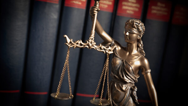 Statue of justice on books background alternate text for this image