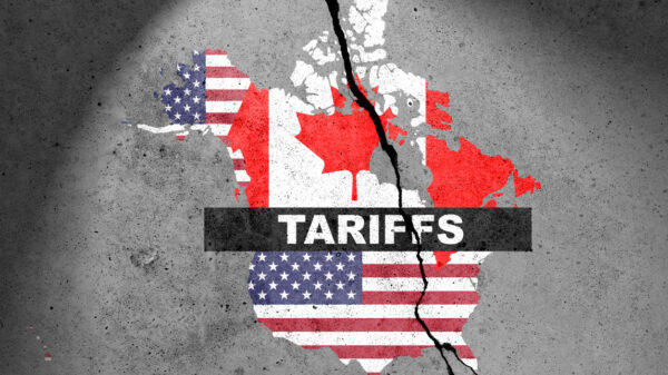 Canada and USA flags map painted on the concrete wall with word TARIFFS. Duty, trade, customs and tariffs war alternate text for this image