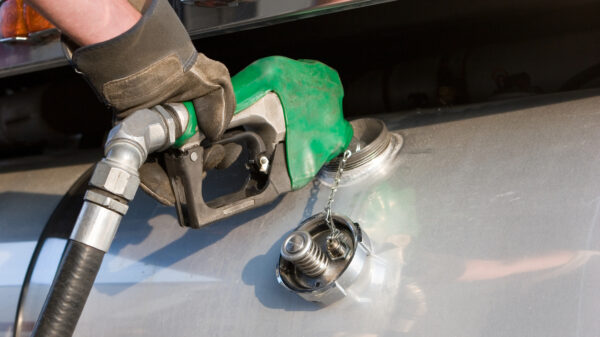 A man fuelling up a freight transport truck alternate text for this image