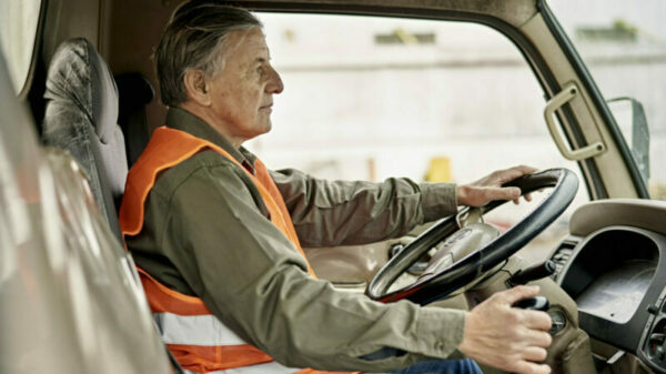 Portrait of Early 60s Trucker Sitting in Driver’s Seat alternate text for this image
