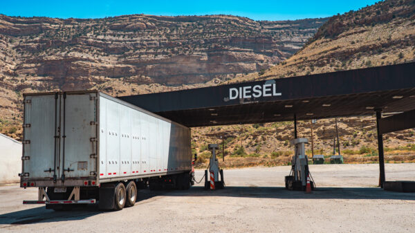 Box trailer refuels at diesel station in desert canyon of Western USA during midday — static shot alternate text for this image