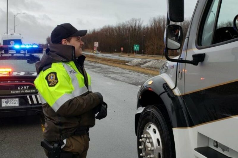 Policier de la SQ avec camion arrêté sur la route