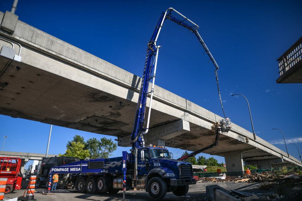 Camion pompe à béton près d’une voie surélevée