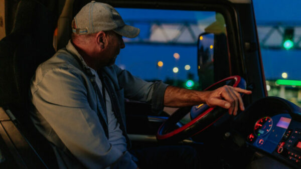 Adult man turning the wheel of a truck into the right alternate text for this image
