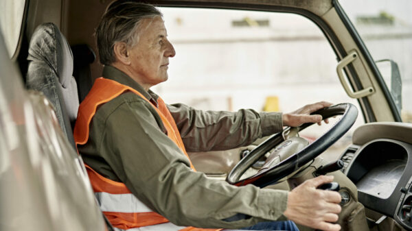 Portrait of Early 60s Trucker Sitting in Driver’s Seat alternate text for this image