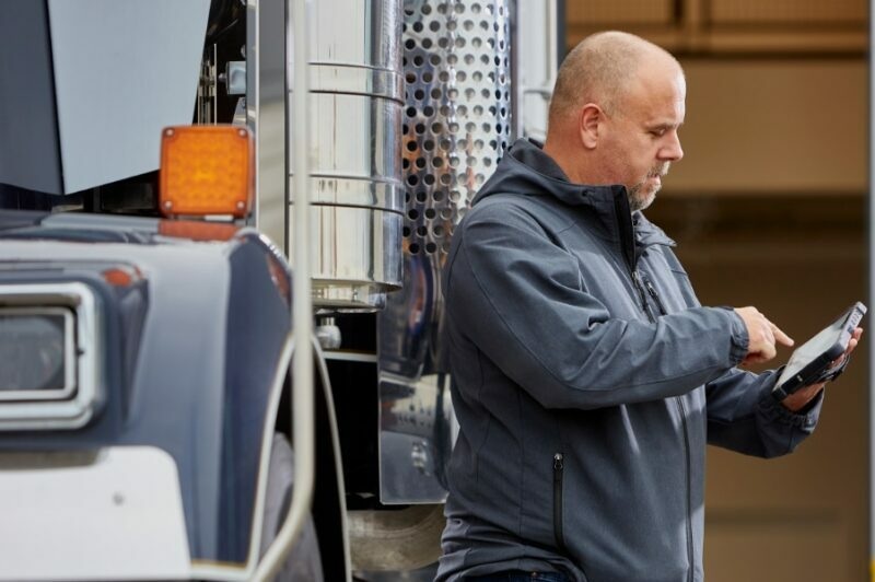 Chauffeur utilise une tablette devant son camion