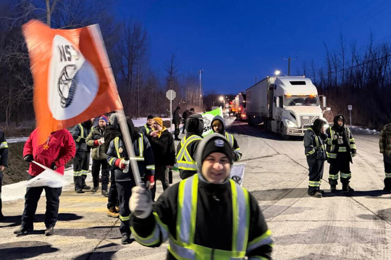 Grévistes du Groupe Metro avec camions en arrière-plan