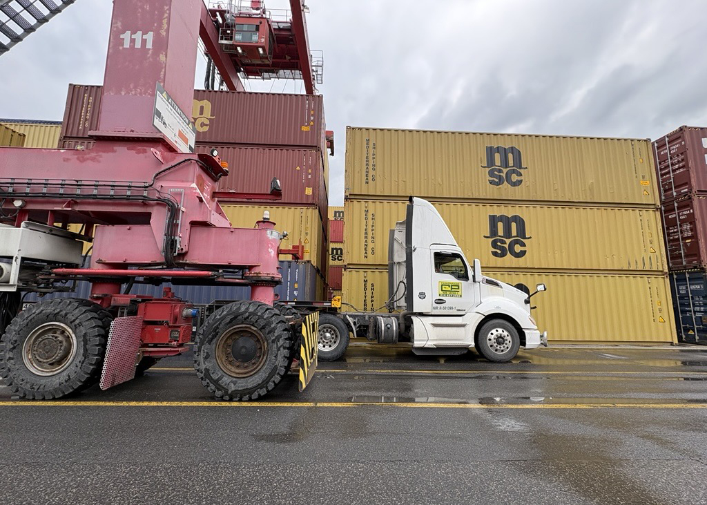 Grue charge un conteneur sur un camion au port de Montréal