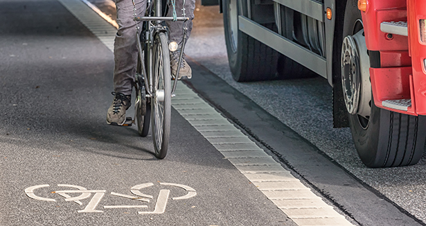 Flanc de camion à côté d’un cycliste