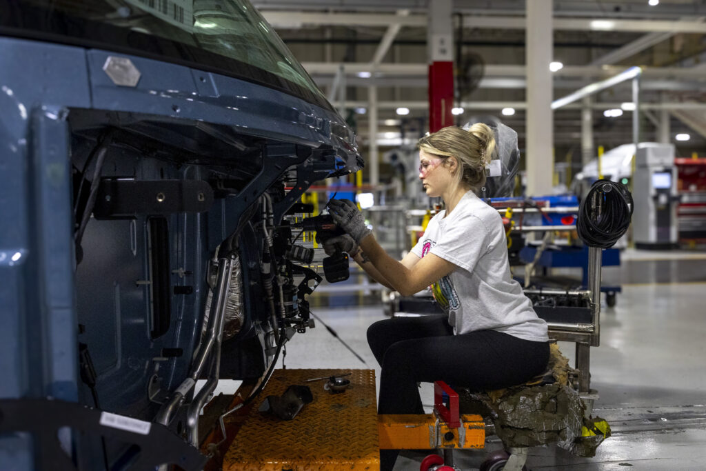 Ouvrière travaille sur le devant d’un camion Volvo en usine