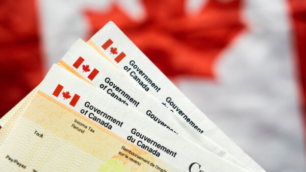 Canada Government Tax Refund Cheques with Canadian flag in the background, benefit cheque Canadian Government alternate text for this image
