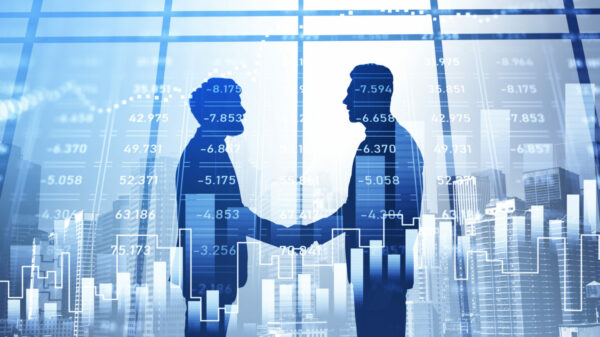 Silhouettes of businessmen having a handshake. Panoramic city view in the background. Financial charts in the foreground. Concept of networking and cooperation on stock market alternate text for this image