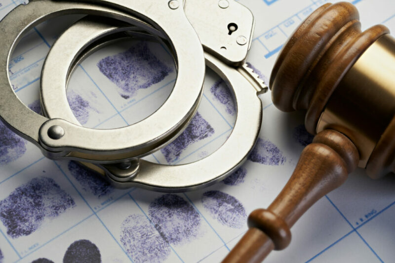 Menottes, empreintes digitales imprimées sur une feuille blanche et marteau de juge