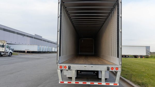 Empty semi-truck trailer in warehouse alternate text for this image