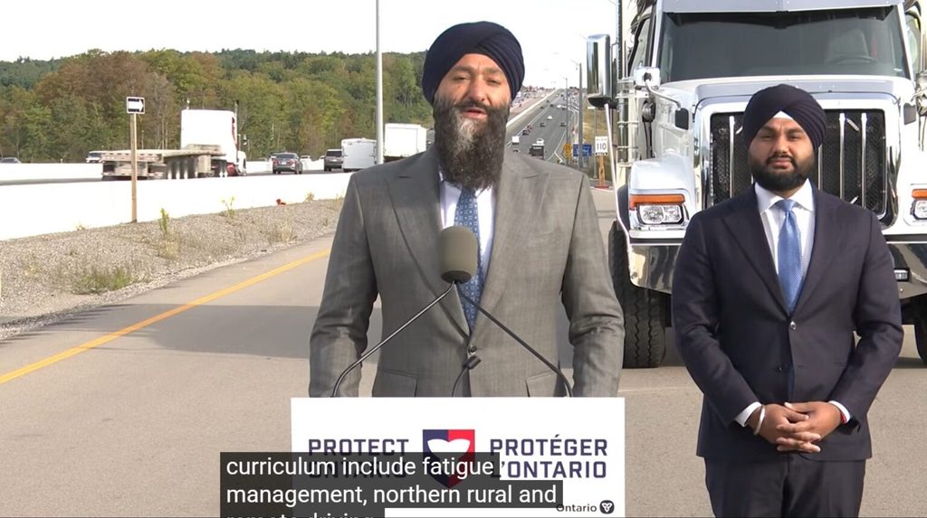 Ministre des Transports de l’Ontario, Prabmeet Sarkaria, devant un  camion lourd.